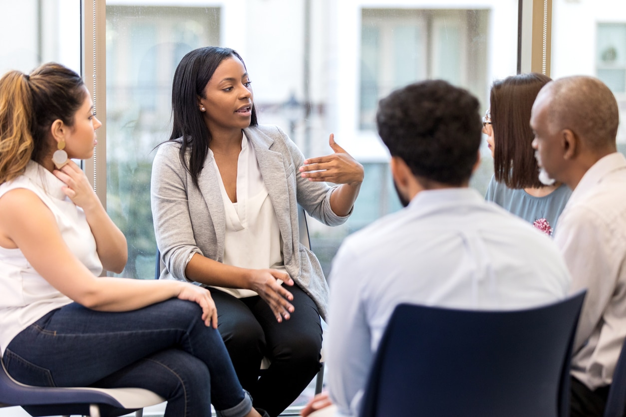 a group of people sitting in a chair talking on a cell phone